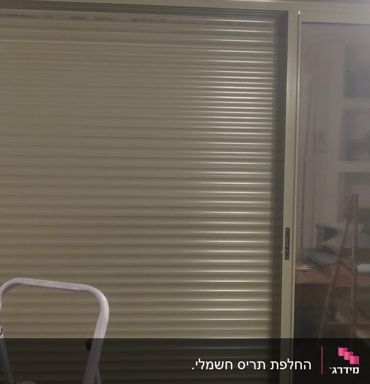 תריס גלילה סגור ליד חלון זכוכית